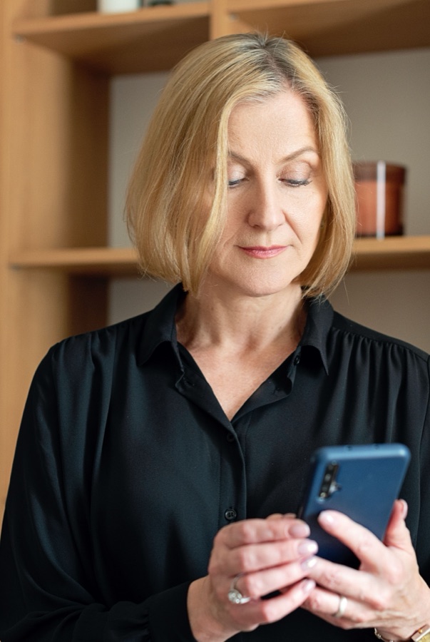 A host checking the MyCleans app on her phone